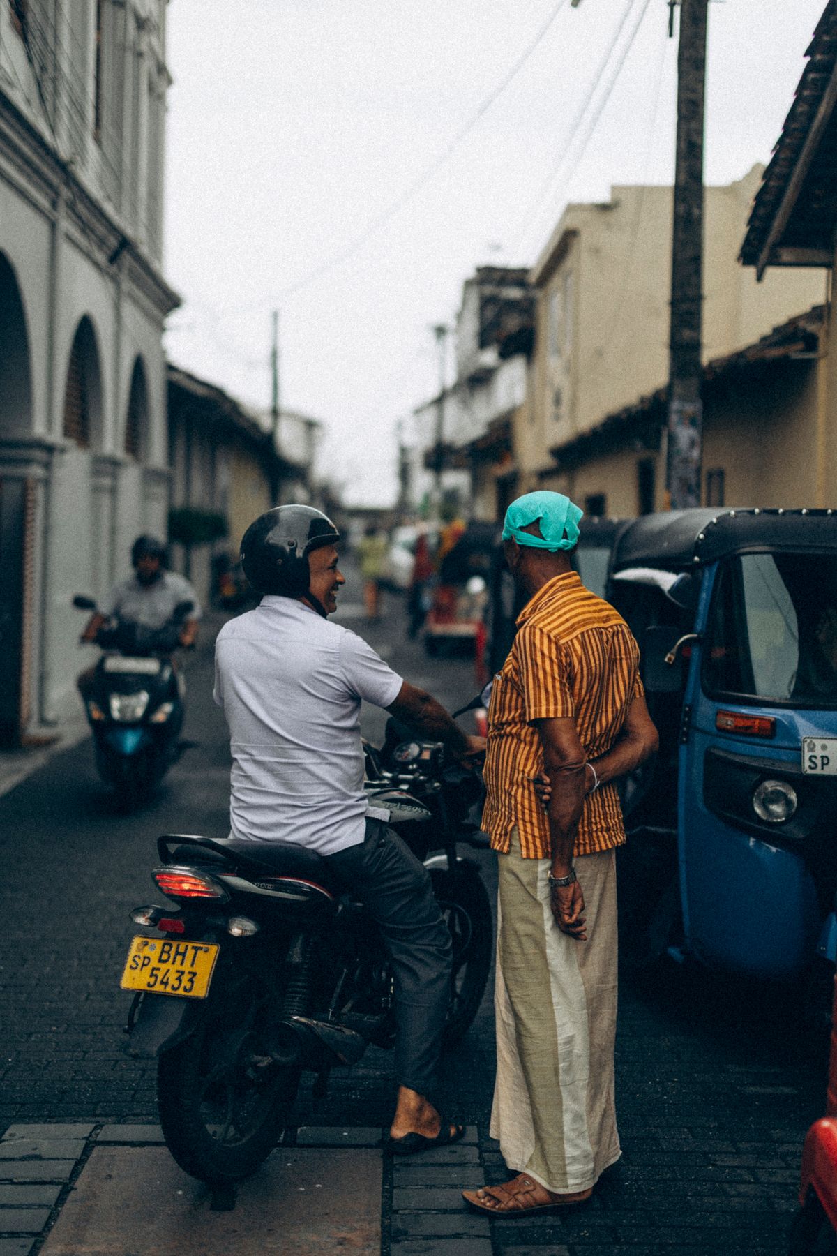 Two people in conversation on a street in Galle, Sri Lanka.